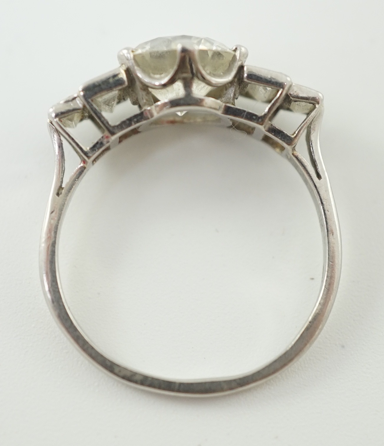 A platinum and single stone diamond ring, with graduated baguette cut diamond set shoulders